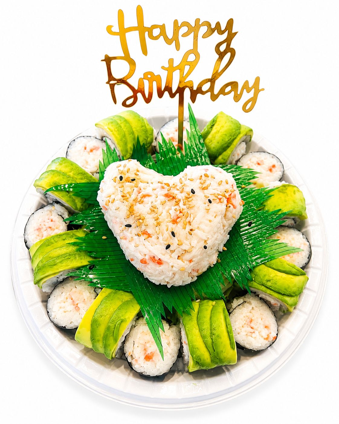 A top-down view of a round white plate filled with sushi rolls and a heart-shaped rice centerpiece, decorated with green seaweed, avocado slices, sesame seeds, and a gold 'Happy Birthday' script topper on a white background.