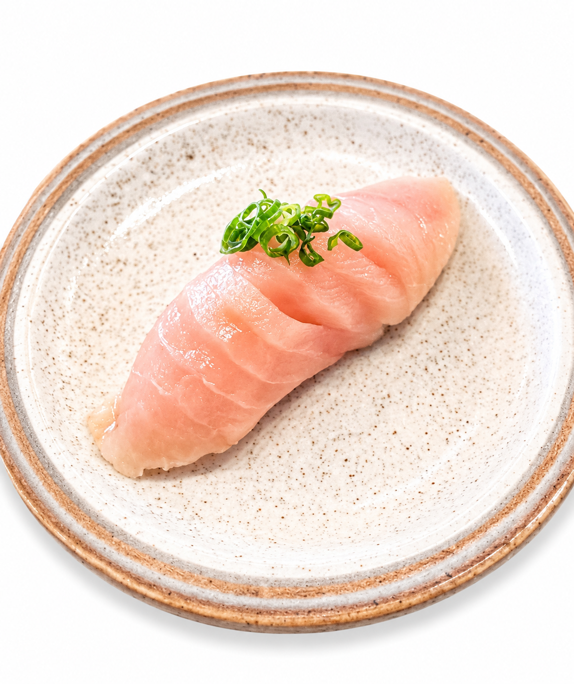 A single piece of pink tuna sushi on a speckled beige ceramic plate with a brown rim, garnished with chopped green scallions, on a white background.
