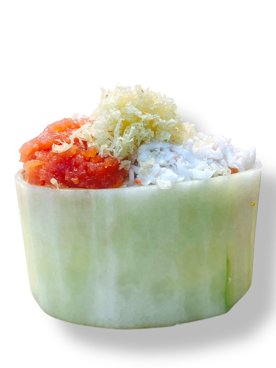 Cucumber boat filled with rice, imitation crab, and spicy tuna on a white background