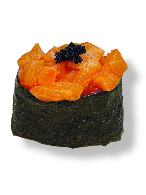 Spicy salmon gunkan sushi made with fresh diced salmon in spicy sauce, wrapped in seaweed and topped with black tobiko on a white background